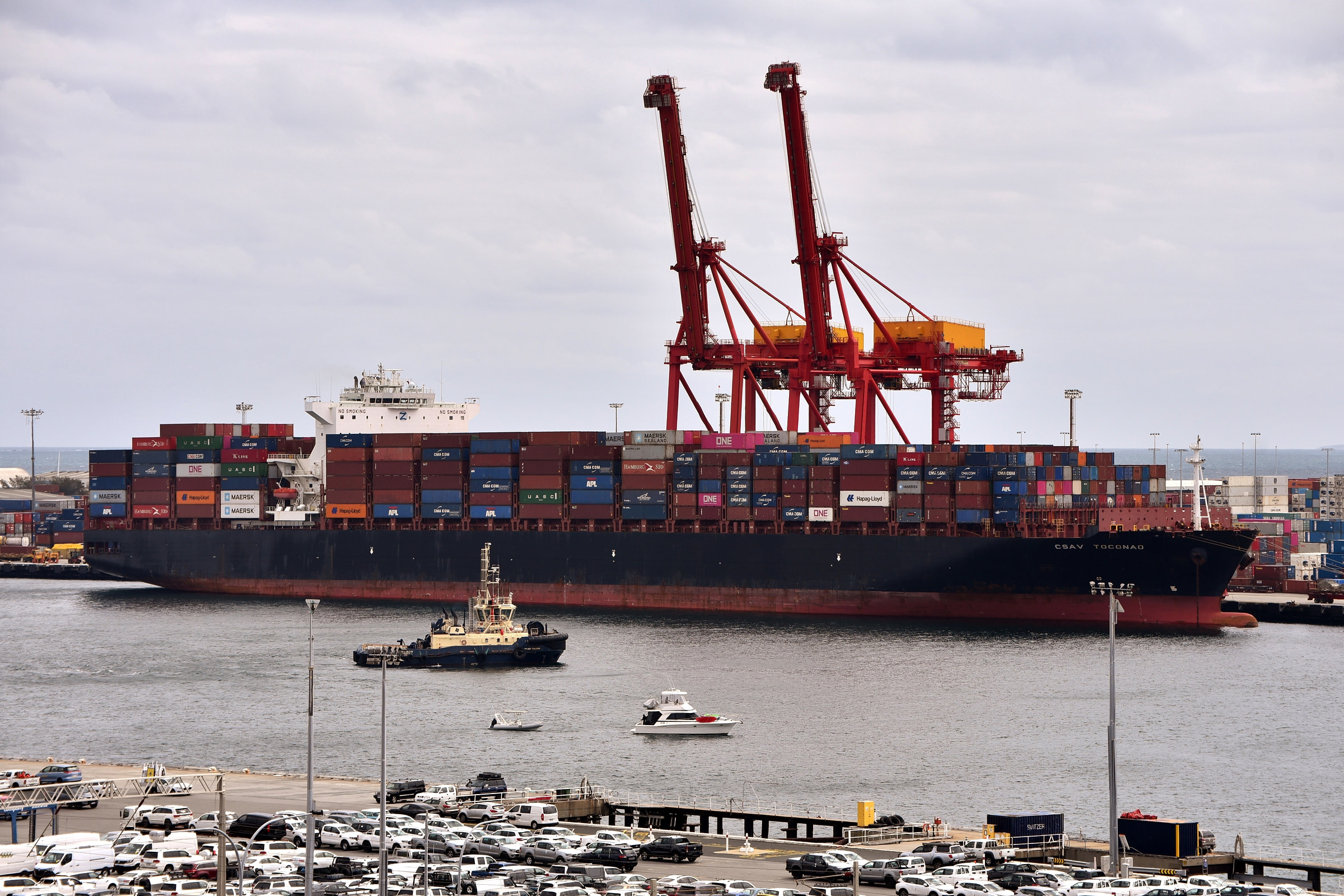 Container vessel at berth beneath port cranes